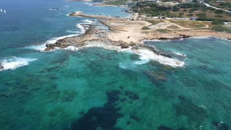 Agios-georgios-beach-in-cyprus,-showcasing-turquoise-waters-and-rugged-coastline,-aerial-view