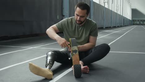 sportsman fixing prosthetic running blade with wrench