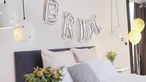 room decorated with flowers and balloons with the word 'bride' above the bed