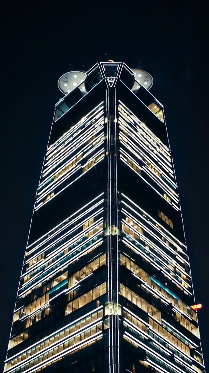 A modern skyscraper illuminated at night