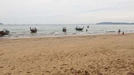 boats and people interacting on sandy beach