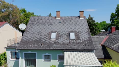 Flying-Towards-Gray-Eternit-Roof-Tiles-Of-A-Structure