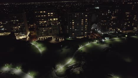 city of mar del plata at night in argentina. aerial view of urban tall buildings and park.