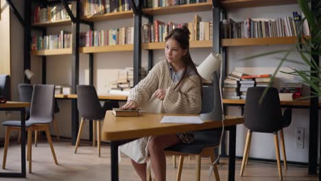 una adolescente estudiando en una biblioteca