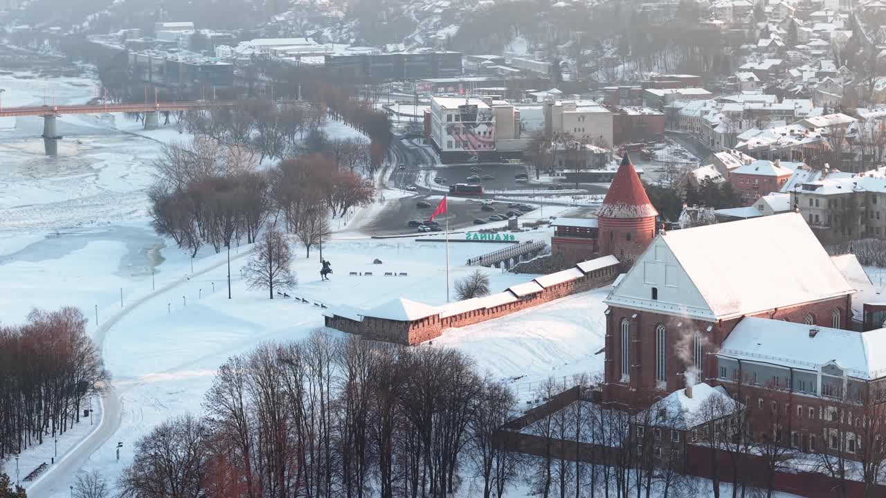 Droneoptagelser af det imponerende, sneklædte Kaunas Slot, beliggende i det maleriske vinterlandskab i Kaunas' gamle bydel. Et fredfyldt, frostklart panorama med blød belysning.