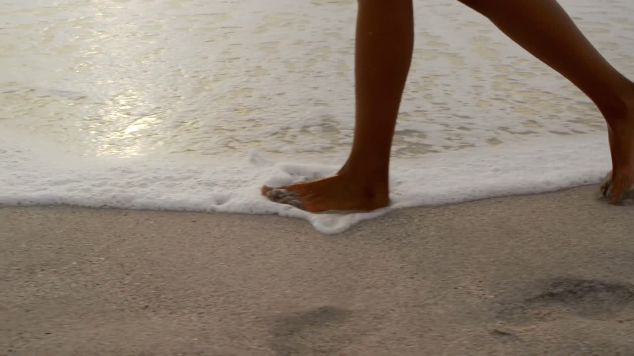 sección baja de la mujer caminando en la playa 4k