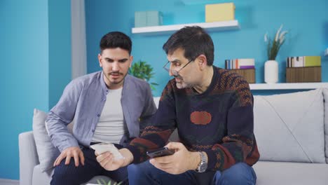 Hijo-Ayudando-A-Padre-Que-No-Puede-Usar-El-Teléfono.