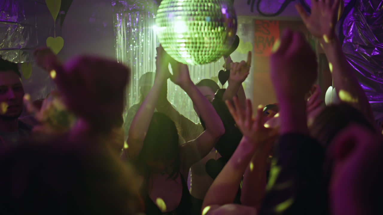 Young people grooving party with festive decoration. Joyful youngsters dancing