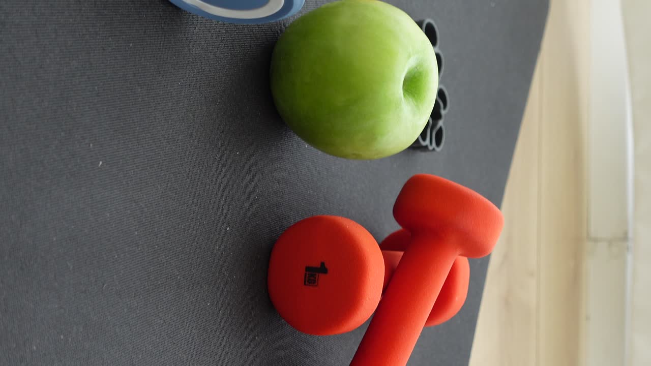 Dumbbell, apple, exercise mat and massage ball