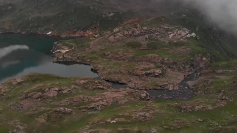 Drone-takes-an-aerial-shot-of-the-beautiful-and-green-Patlian-lake-located-in-Kashmir,-Pakistan