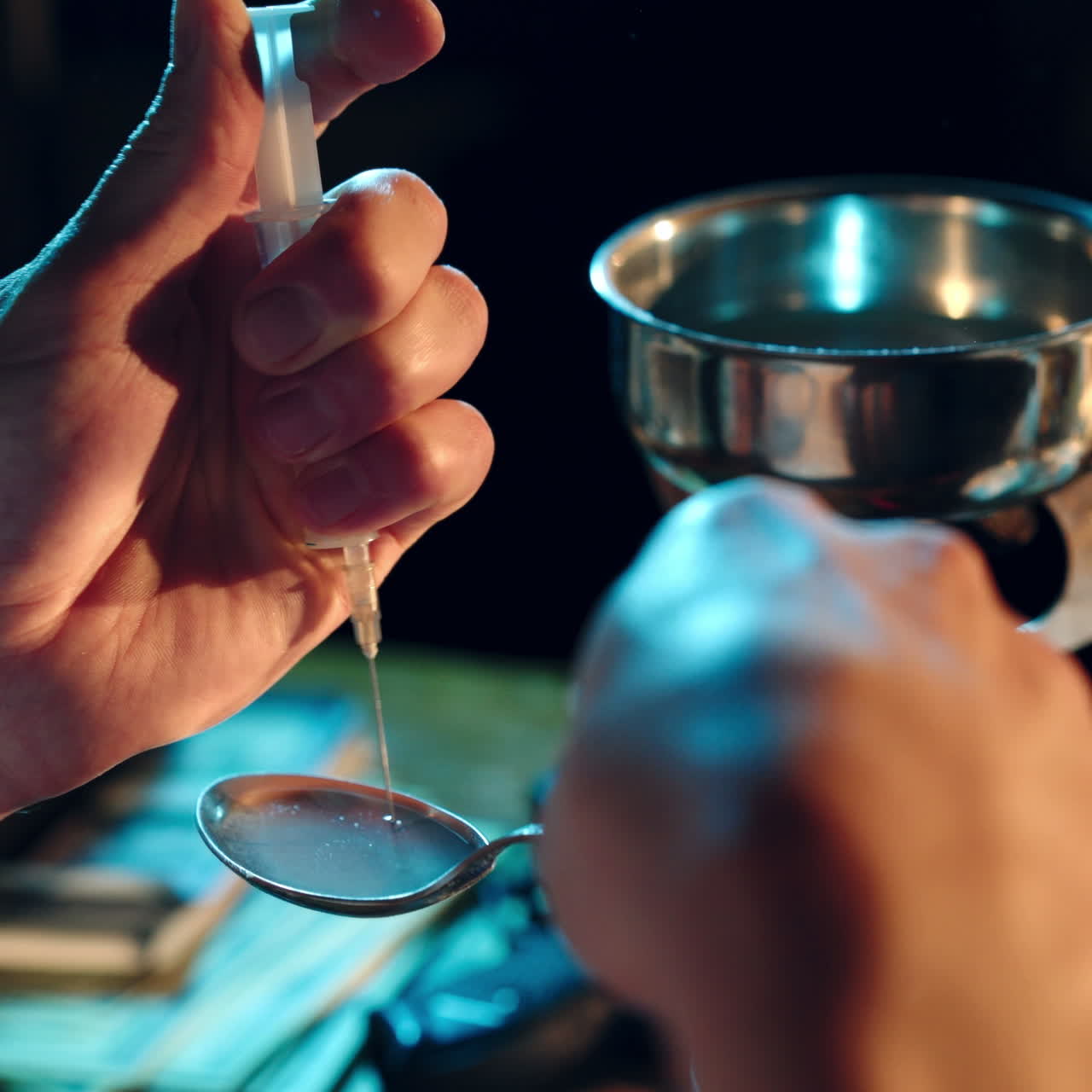 Man is a drug addict sitting at the table makes drugs. The concept of social problems of drug addiction and crime.