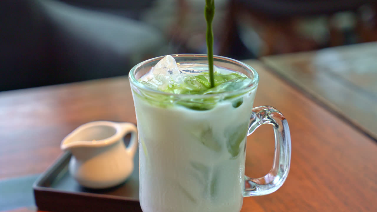 verter té verde matcha en un vaso de leche