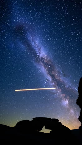 milky way over rock arch at night