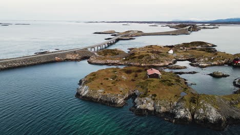 ノルウェーの大西洋道路にあるストルセイスンデットとハルヴァーゲン橋のある岩だらけの島のボートハウス