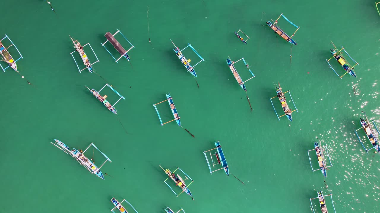 열대 섬 발리 근처의 푸른색 투명한 파도에서 흔들리는 인도네시아의 전통적인 주킹 보트의 상승하는 공중 풍경