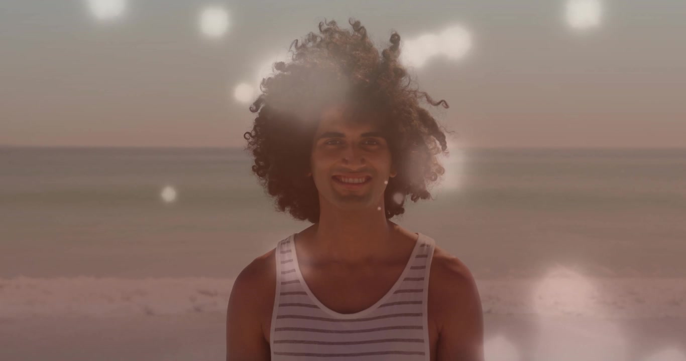 Ein einzelner Mann steht bei Sonnenuntergang am Meer, während leuchtende Kugeln eintreten, um seinen Oberkörper schweben und die Gesundheit fördern.