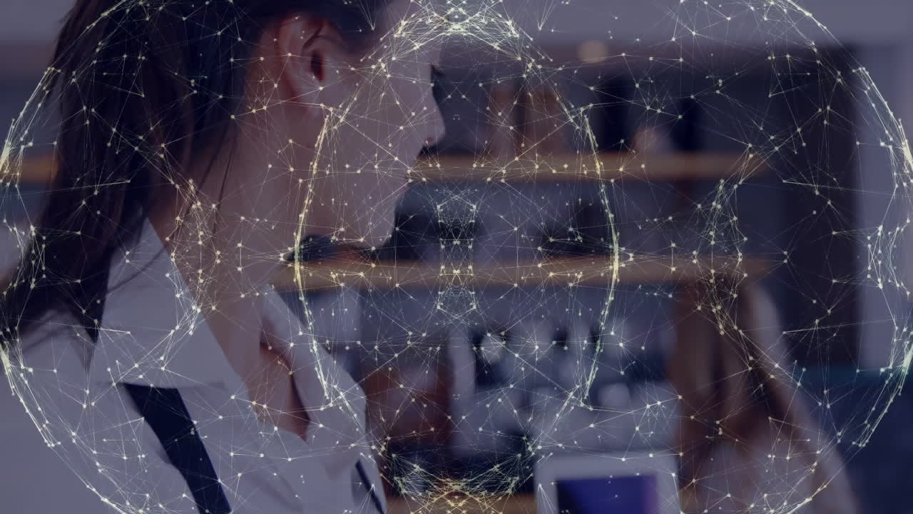 woman using smartphone and colleague working laptop in tech office, showing network overlay graphic