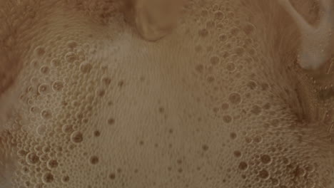 Top-down-view-of-cola-being-poured-in-glass-and-filling-up-while-foaming