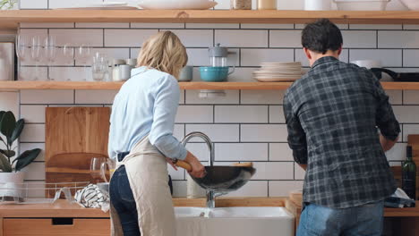 Pareja-En-La-Cocina-Limpiando-Platos-Juntos