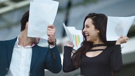 Closeup-couple-throwing-papers-in-slow-motion.-Couple-celebrating-victory