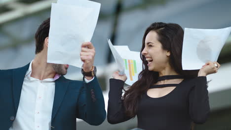 una pareja de primer plano lanzando papeles a cámara lenta. una pareja celebrando la victoria.