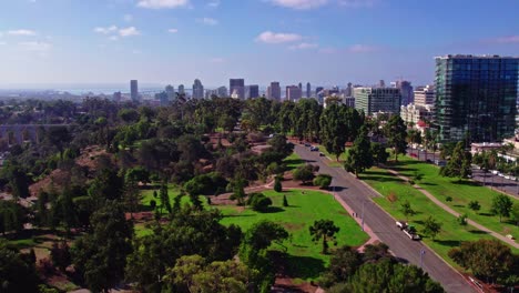 Aerial-View-of-Suburban-Area-District-of-San-Diego-California,-Urban-Streets-Roads-and-Modern-Buildings-on-Top-of-Green-Hill-Park,-Downtown-Cityscape-Skyline-with-Coronado-bridge-in-Horizon