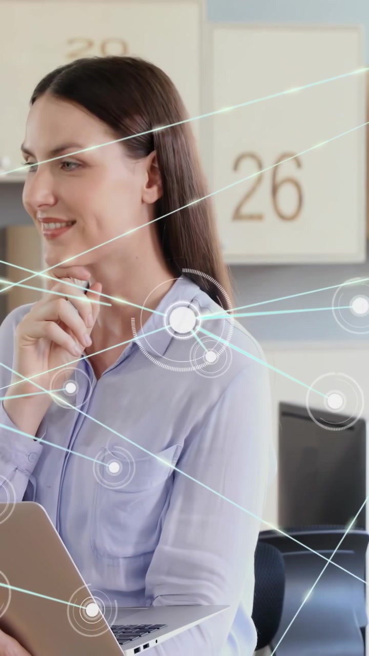 Video verticale: Donna in ufficio che digita al portatile, con un'interfaccia HUD tecnologica che pulsa su di lei mentre analizza i dati.