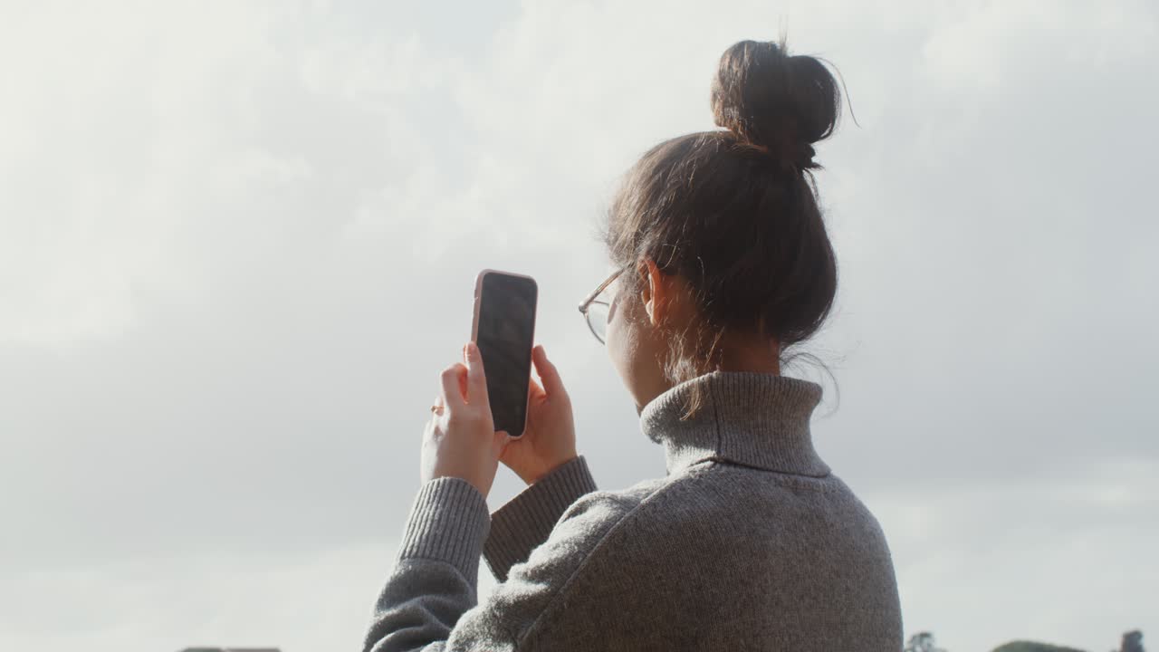 mujer tomando una foto del coliseo en roma