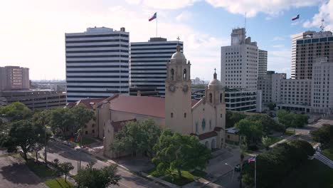 Toma-Aérea-De-Una-Iglesia-Católica-Histórica-En-El-Centro-De-Corpus-Christi-Con-Edificios-En-El-Fondo