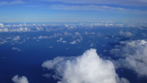 an aerial perspective of clouds floating above the vast expanse of the ocean during the day