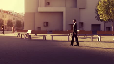 man in a suit walking across an urban plaza with sunlight and benches