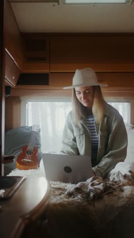 woman working on a laptop in a camper van