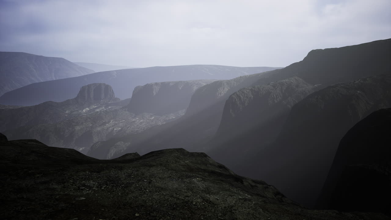 Misty mountain ranges reveal majestic cliffs under a cloudy sky