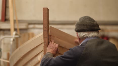 experienced shipwright checking boat angle, traditional wooden boat construction