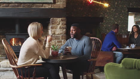 couple sitting at table drinking tea in traditional english holiday hotel