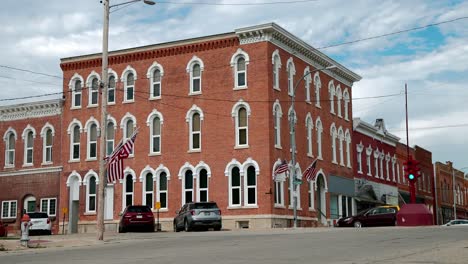 Antique-stoplight-in-downtown-Toledo,-Iowa-with-flags-flying