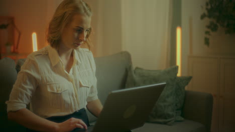 mujer trabaja en una computadora portátil en casa navegando por internet por la noche
