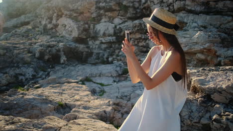 mujer tomando fotos en la costa