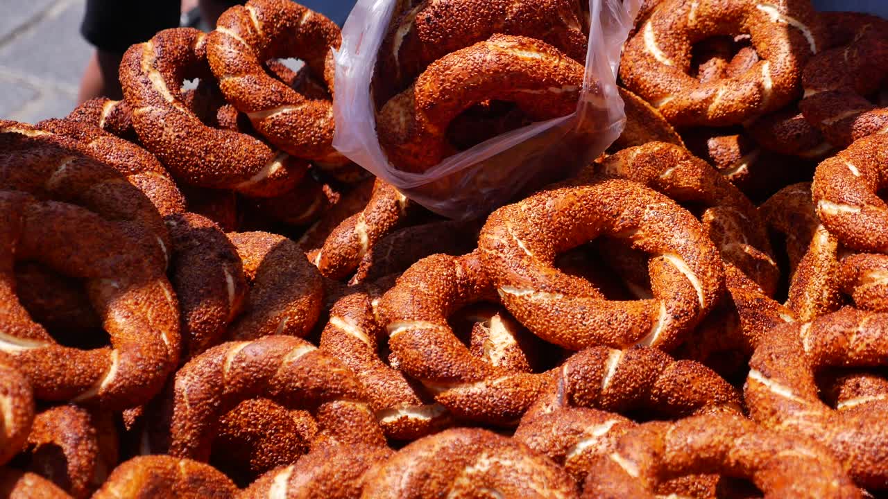A close-up of a large pile of traditional Turkish simit (sesame bagels)