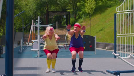 Senior-grandmother-and-grandfather-sports-team-doing-squatting-fitness-exercising-on-playground