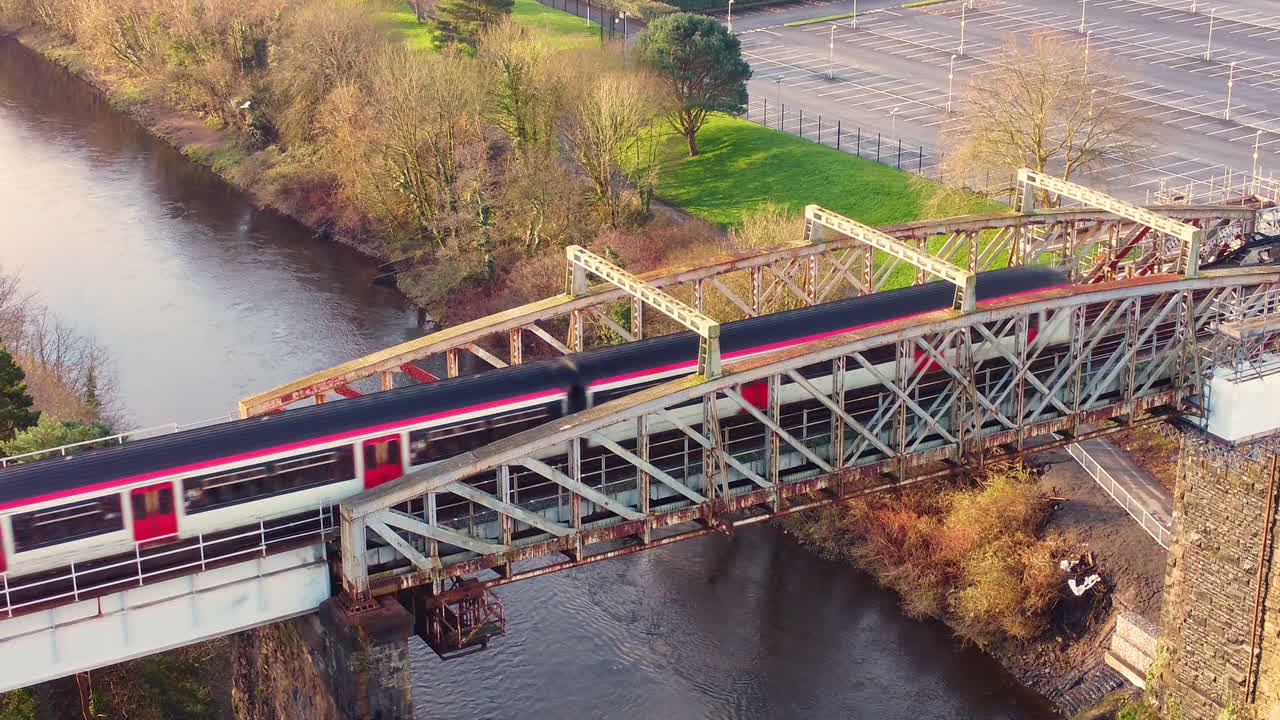 Veduta aerea di un treno che passa su un ponte sopra un fiume. Passeggeri pendolari su ferrovia in transito verso la destinazione. Esempio di moderna rete di trasporti.