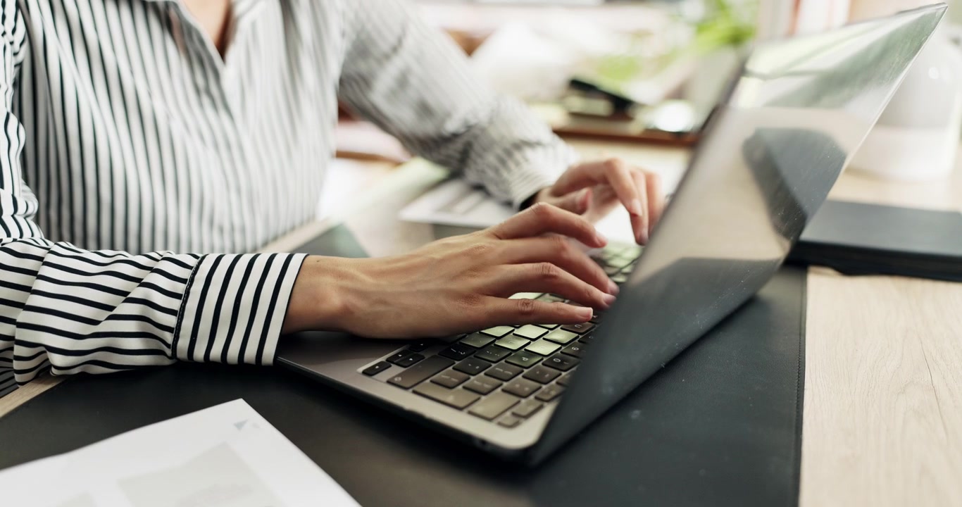 Professional Woman Typing on Laptop in Office Setting