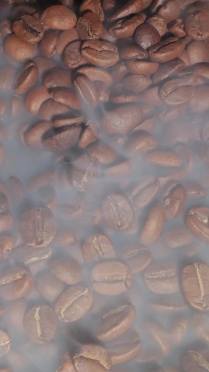 Sfondo di chicchi di caffè tostati fumanti con messa a fuoco selettiva