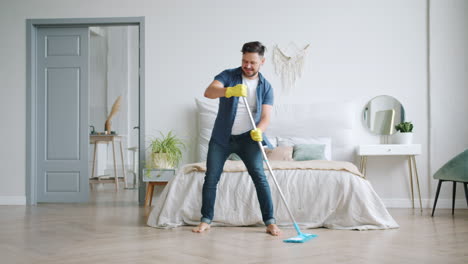 man having fun while mopping the bedroom floor