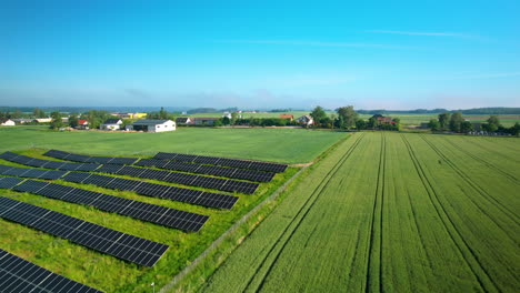 Flying-Over-Solar-Panels-And-Green-Fields-In-The-Countryside---aerial-drone-shot