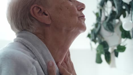 Close-up-of-senior-woman-checking-skin-condition-in-the-bathroom-mirror