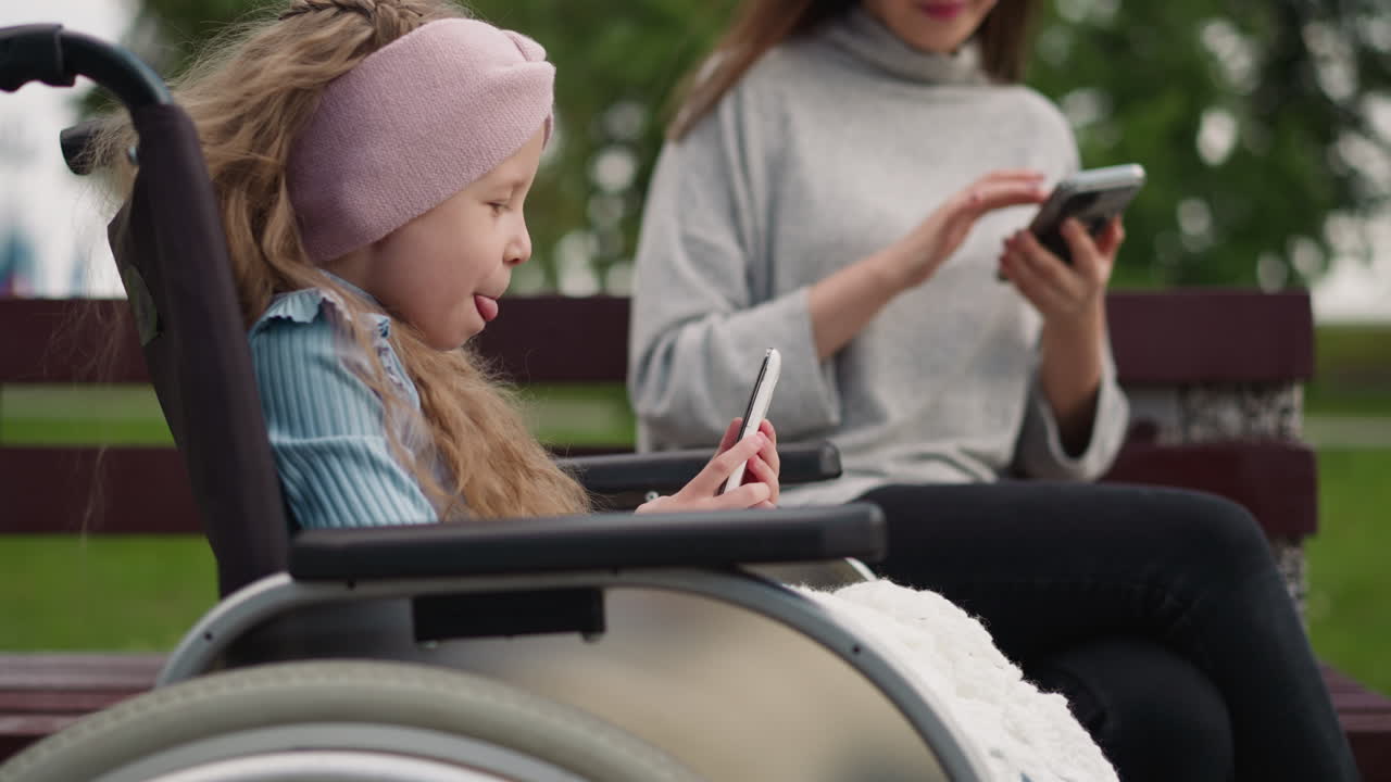 chica linda toma selfies mientras la mamá lee las noticias en el teléfono inteligente