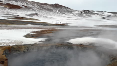 Close-up-of-fumes-rising-up-of-snowy-Geothermal-Area-in-Iceland-during-winter---tilt-up