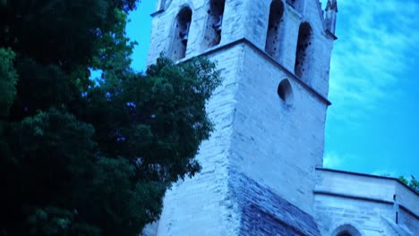 wave a church high in france avignon in good weather with a tree next to it