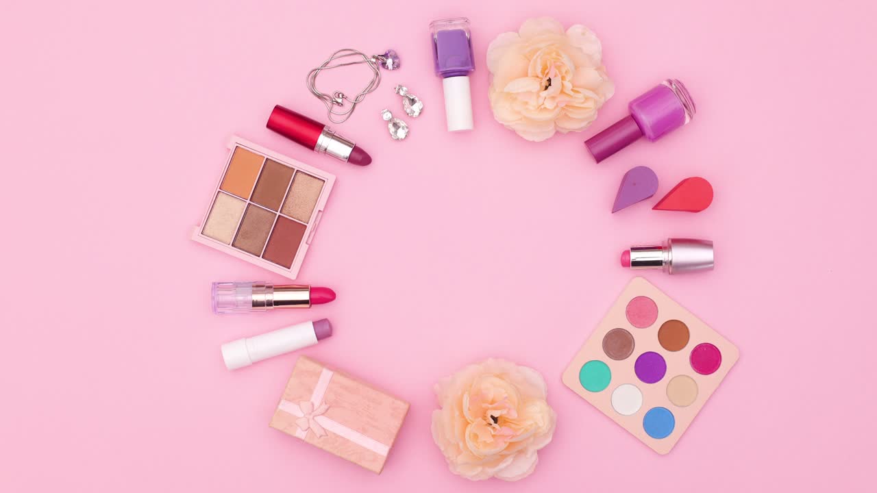 Make up products and beauty accessories move in circle on pink theme. Stop motion